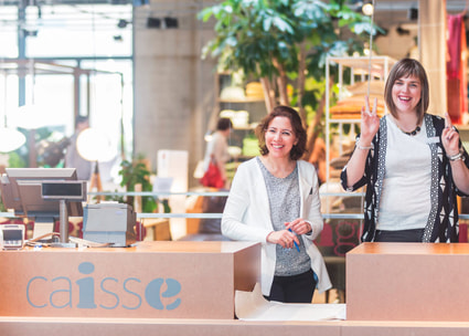 Lachende Mitarbeiterinnen an der Kass Lachende Mitarbeiterinnen an der Kasse